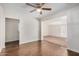 Open-concept living space with hardwood floors leading to a carpeted area with sliding glass doors at 3611 W Hazelwood St, Phoenix, AZ 85019