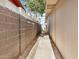 Narrow side yard, partially graveled, enclosed with block wall and paneled wall at 3611 W Hazelwood St, Phoenix, AZ 85019