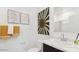 Bright bathroom with a framed botanical art, a large vanity with marble countertop and white cabinets at 38135 W Bello Ln, Maricopa, AZ 85138