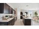 Spacious kitchen featuring stainless steel appliances, dark wood cabinets, and an island with barstool seating at 38135 W Bello Ln, Maricopa, AZ 85138