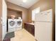 Well-equipped laundry room with washer, dryer, sink and ample storage at 3912 E Williams Dr, Phoenix, AZ 85050