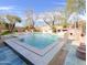 Inviting backyard pool with stone accents, outdoor fireplace, and a serene waterfall feature at 3912 E Williams Dr, Phoenix, AZ 85050