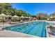 A lap pool with multiple lanes, adorned with sunshades and lounge seating offers a refreshing place for exercise at 3912 E Williams Dr, Phoenix, AZ 85050