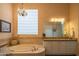 Elegant primary bathroom features a soaking tub and a stylish chandelier at 40607 N Candlewyck Ln, Phoenix, AZ 85086