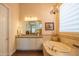 Elegant bathroom with tub, vanity, chandelier, and decorative accents, bathed in soft light at 40607 N Candlewyck Ln, Phoenix, AZ 85086