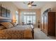 Inviting bedroom with ceiling fan, plush bed, wooden furniture, and plantation shutters for soft light at 40607 N Candlewyck Ln, Phoenix, AZ 85086