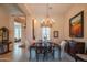 Elegant dining room with a chandelier, a dark wood table, and unique decor and a large painting at 40607 N Candlewyck Ln, Phoenix, AZ 85086