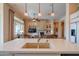 Open-concept kitchen featuring a large island with seating and views of the living room and fireplace at 40607 N Candlewyck Ln, Phoenix, AZ 85086