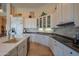 Bright kitchen featuring white cabinetry, stone backsplash, granite countertops, and a large island with a sink at 40607 N Candlewyck Ln, Phoenix, AZ 85086