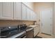 Well-organized laundry room with ample cabinet space and modern appliances at 40607 N Candlewyck Ln, Phoenix, AZ 85086