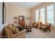 Comfortable living room with a sofa, armchairs, and natural light streaming through the window at 40607 N Candlewyck Ln, Phoenix, AZ 85086