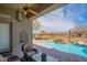 Covered patio with seating overlooks a waterfall pool, spa and desert view at 40607 N Candlewyck Ln, Phoenix, AZ 85086