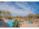 Backyard with a pool, spa, desert landscaping, and mountain views beyond the wrought iron fence at 40607 N Candlewyck Ln, Phoenix, AZ 85086