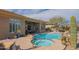 Backyard featuring a built-in pool and spa, covered outdoor living area, and desert landscaping at 40607 N Candlewyck Ln, Phoenix, AZ 85086