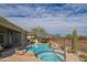 Backyard oasis featuring a pool, spa, and desert landscaping, with mountain views beyond the fence at 40607 N Candlewyck Ln, Phoenix, AZ 85086