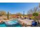 Backyard with a spa, desert landscaping, and mountain views beyond the black wrought iron fence at 40607 N Candlewyck Ln, Phoenix, AZ 85086