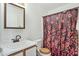 Cozy bathroom featuring single sink, toilet, and shower with floral patterned curtain at 43556 W Colby Dr, Maricopa, AZ 85138