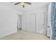 Cozy bedroom featuring neutral carpet, ceiling fan, and sliding door closet at 43556 W Colby Dr, Maricopa, AZ 85138