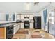 Functional kitchen layout, black appliances, and ample counter space for meal preparation at 43556 W Colby Dr, Maricopa, AZ 85138