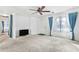 Spacious living room featuring cozy carpeting, a ceiling fan, and lots of natural light at 43556 W Colby Dr, Maricopa, AZ 85138