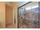 Bathroom featuring a modern glass shower with stone tile and neutral walls at 43573 W Blazen Trl, Maricopa, AZ 85138