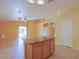 Kitchen island with granite countertop overlooks hardwood floors in the living area with sliding glass doors at 43573 W Blazen Trl, Maricopa, AZ 85138