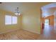 Sunny living room with wood floors, large window and open archway to another living space at 43573 W Blazen Trl, Maricopa, AZ 85138