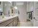 Clean bathroom design featuring light-colored cabinets, double sinks, and a walk-in shower with white tiling at 4750 S Rhodium Ln, Mesa, AZ 85212