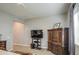 A comfortable bedroom area with a TV, complemented by a detailed wooden dresser and soft, neutral carpeting at 4750 S Rhodium Ln, Mesa, AZ 85212