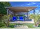 An inviting outdoor kitchen with seating area under a stylish pergola, with lush landscaping at 4750 S Rhodium Ln, Mesa, AZ 85212