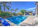 A serene swimming pool surrounded by tropical landscaping and a well-equipped outdoor kitchen at 4750 S Rhodium Ln, Mesa, AZ 85212