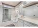 Bright bathroom featuring a shower-tub combo with a sliding glass door, ample counter space and patterned wallpaper at 5043 W Christy Dr, Glendale, AZ 85304