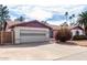 View of a one story home, two-car garage, desert landscaping, and blue sky at 5043 W Christy Dr, Glendale, AZ 85304