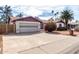 Exterior of a house with desert landscaping, large driveway, and two-car garage at 5043 W Christy Dr, Glendale, AZ 85304