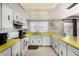 Traditional kitchen featuring white cabinets and appliances, paired with bright yellow countertops at 5043 W Christy Dr, Glendale, AZ 85304