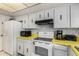 Bright kitchen with white appliances and cabinetry, paired with yellow countertops and wallpapered backsplash at 5043 W Christy Dr, Glendale, AZ 85304