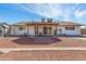 Back exterior with a covered patio, white trim, and a red stone yard at 5256 W Port Au Prince Ln, Glendale, AZ 85306