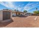 An open backyard features a shed, covered patio, and a spacious yard at 5256 W Port Au Prince Ln, Glendale, AZ 85306