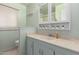 Bathroom with a light green wall, white cabinets, and a decorative accent at 5256 W Port Au Prince Ln, Glendale, AZ 85306