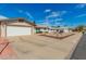 Well-lit, single-story home featuring a two-car garage, desert-style landscaping and a bench at 5256 W Port Au Prince Ln, Glendale, AZ 85306