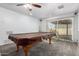 Spacious game room with a pool table covered with brown cloth and a sliding glass door to the backyard at 5256 W Port Au Prince Ln, Glendale, AZ 85306