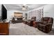 Cozy living room with plush seating, soft carpet, and a decorative ceiling fan at 5256 W Port Au Prince Ln, Glendale, AZ 85306