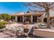 Spacious backyard with a covered patio, barbecue area, and a well-maintained desert landscape at 5902 S Amberwood Dr, Sun Lakes, AZ 85248