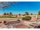 Scenic backyard view overlooking lush golf course with mature trees and manicured landscaping at 5902 S Amberwood Dr, Sun Lakes, AZ 85248