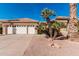 Home exterior showcasing a three-car garage, tiled roof, and desert landscaping with palm trees in the front yard at 5902 S Amberwood Dr, Sun Lakes, AZ 85248