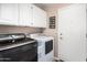 Well-equipped laundry room with modern, front-load washer and dryer and ample cabinet space for organized storage at 5902 S Amberwood Dr, Sun Lakes, AZ 85248