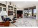 Cozy living area featuring built-in shelving, a fireplace, a large television, and sliding glass doors to the backyard at 5902 S Amberwood Dr, Sun Lakes, AZ 85248