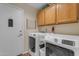 Clean laundry room with a washer and dryer and overhead cabinet storage at 5940 E Taunus Cir, Mesa, AZ 85215