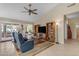 Bright living room with a ceiling fan, tile floor, and access to the patio at 5940 E Taunus Cir, Mesa, AZ 85215