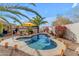 Backyard pool with desert landscaping, patio umbrellas, and colorful plants at 5940 E Taunus Cir, Mesa, AZ 85215